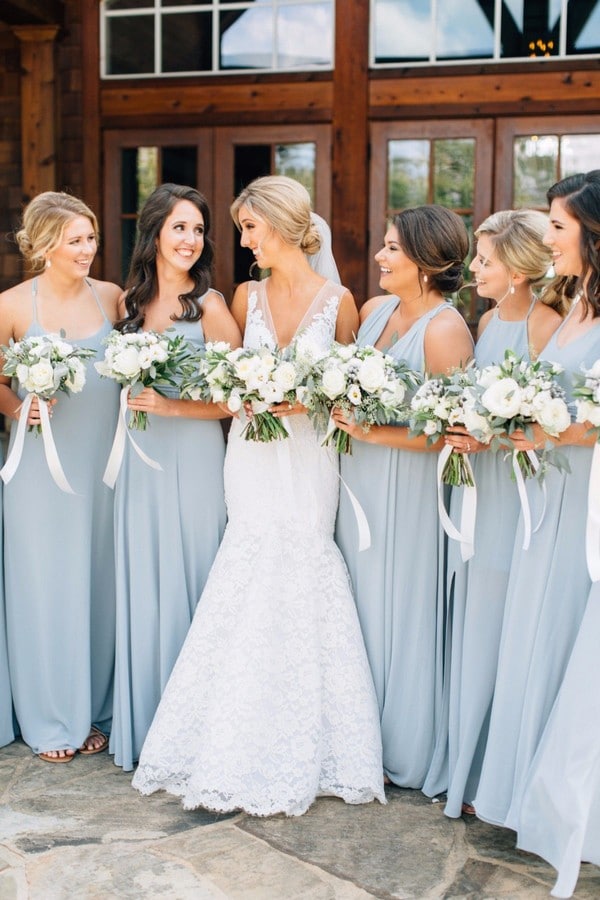 Bridesmaids in steel blue dresses with white and green bouquets