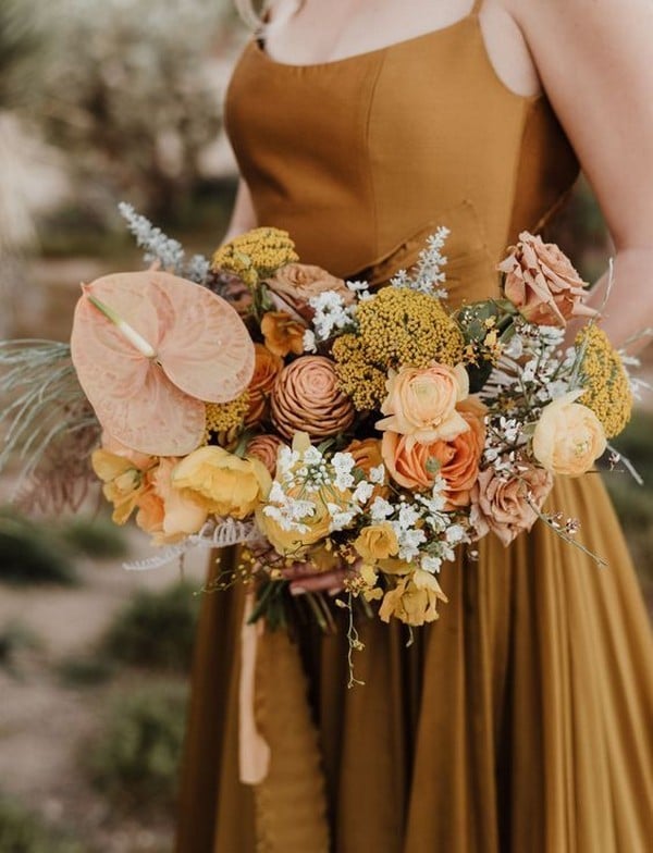 Vibrant wedding bouquet featuring warm sun drenched shades of mustard yellow, clay and orange
