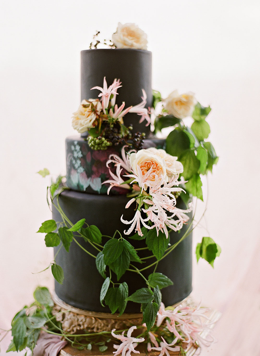 black wedding cake with greenery