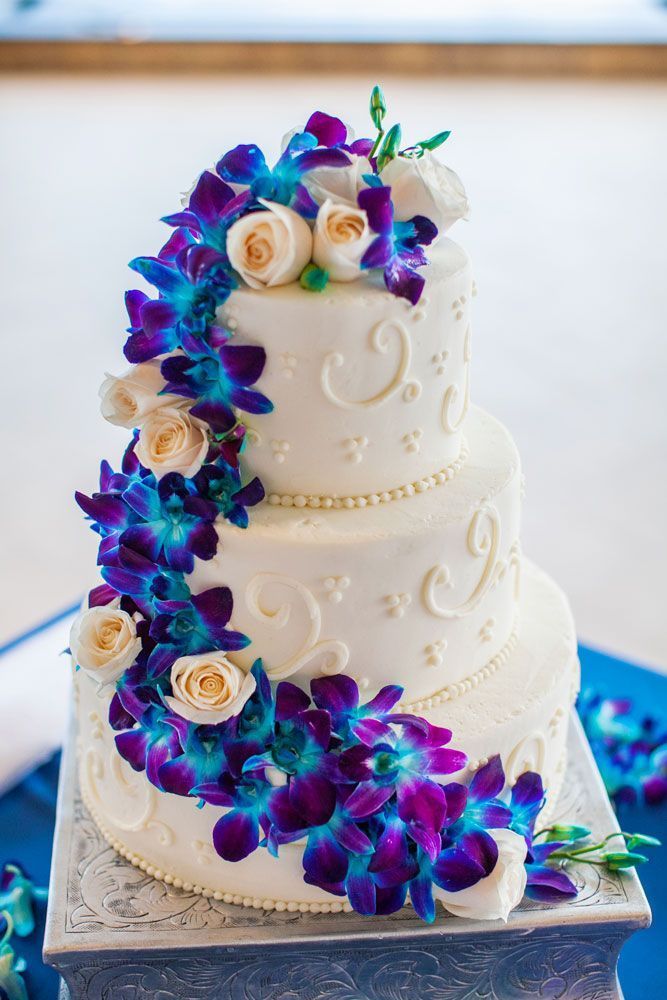 elegant wedding cake with royal blue and purple flowers