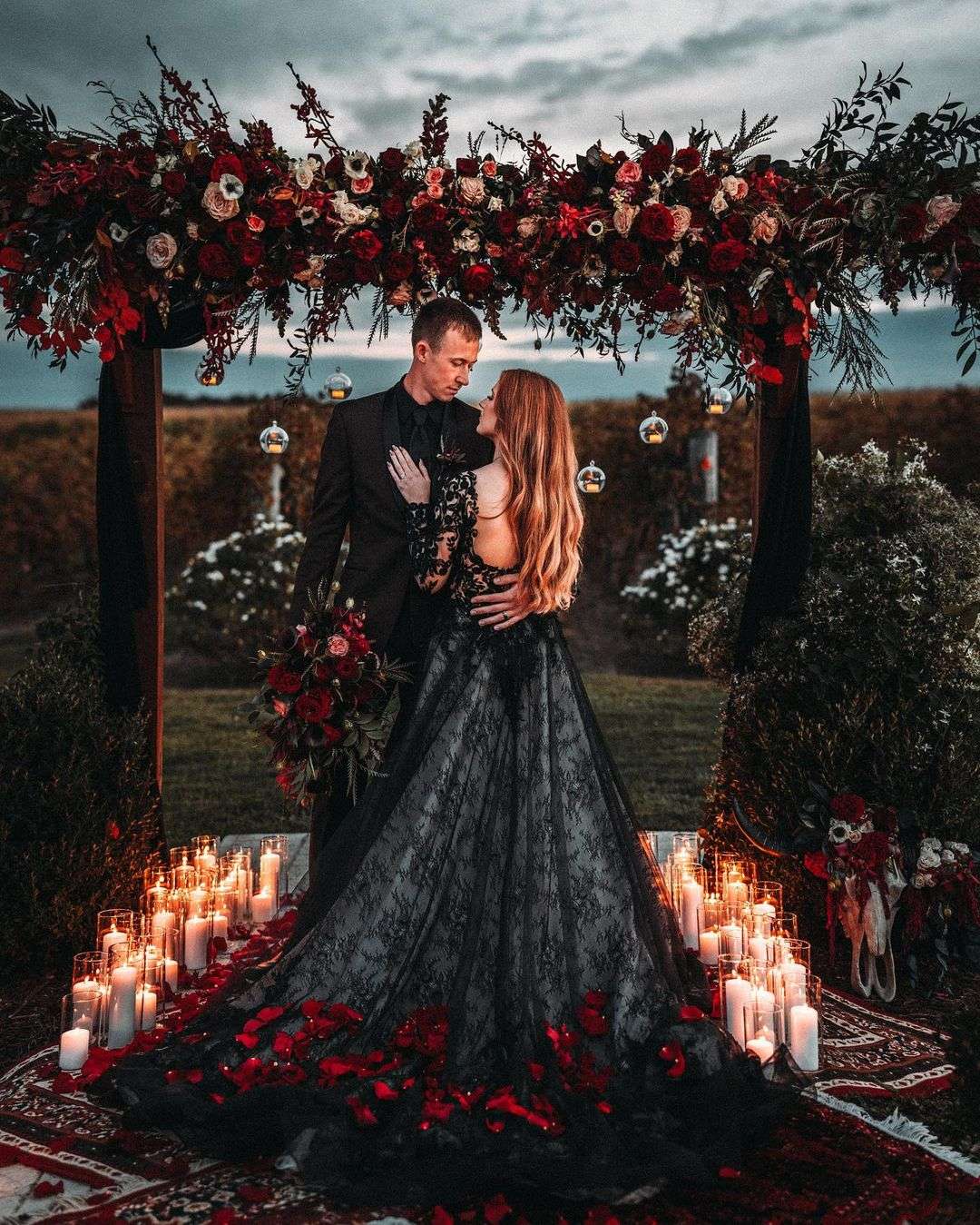 black lace wedding dress with red flower petals