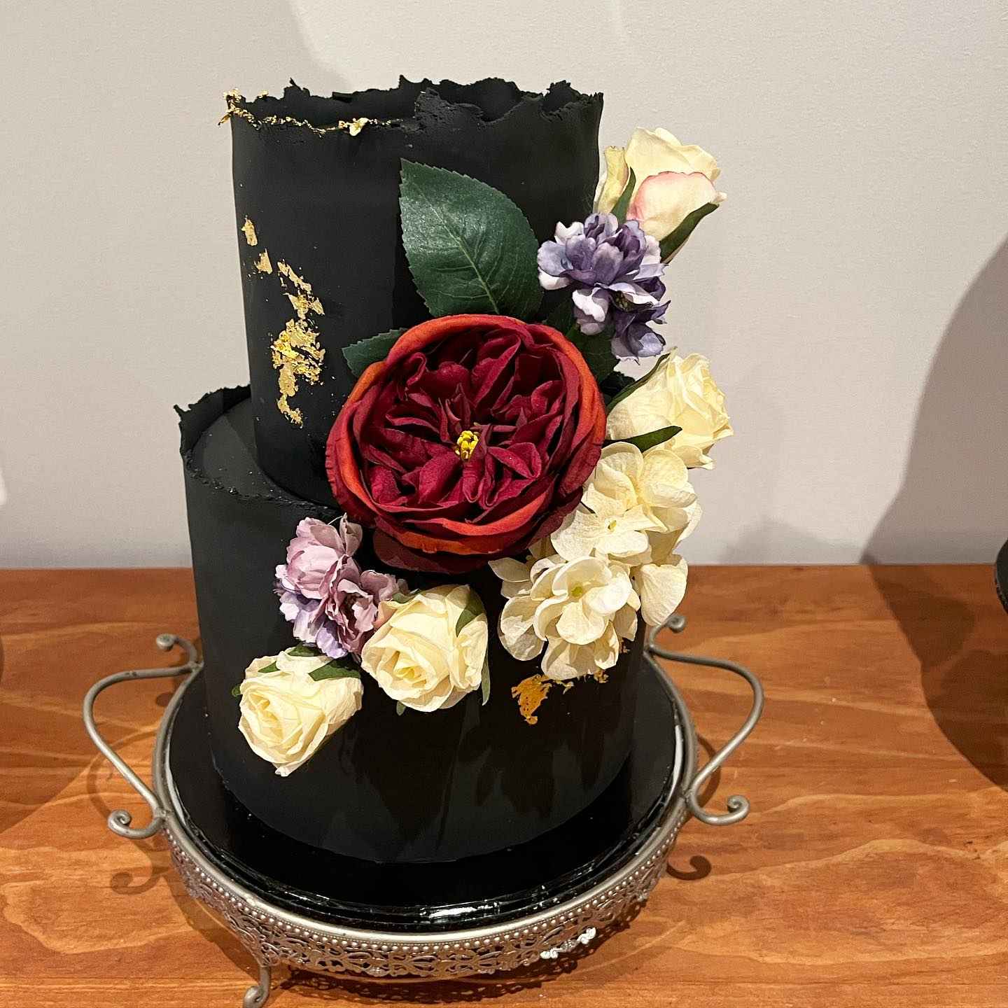 black wedding cake with red yellow and purple flowers via metro_designer_cakes